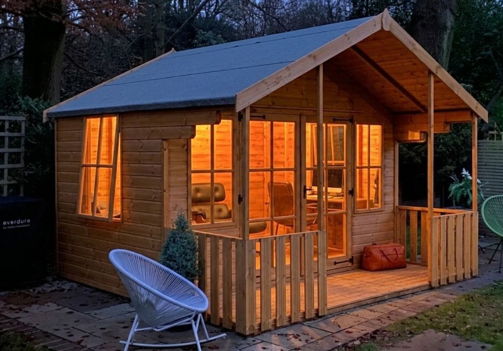 Illuminated wooden summer house with veranda
